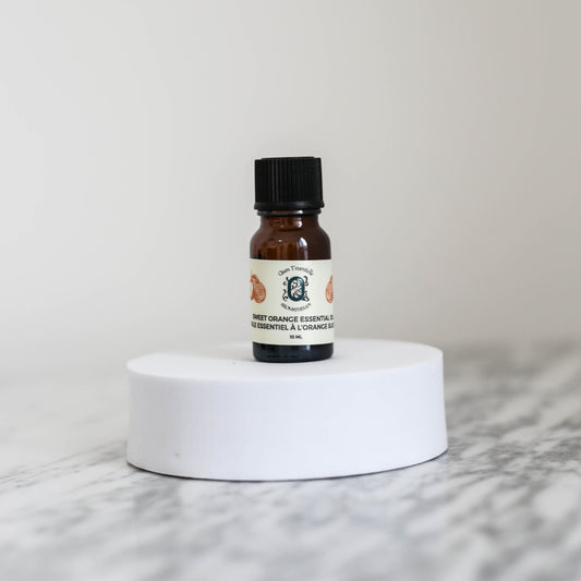 Sweet Orange Essential Oil 10ml bottle by Quen T’essentielle Aromatherapy, displayed on a white pedestal with minimalist background – natural essential oil for uplifting and refreshing aromatherapy use.